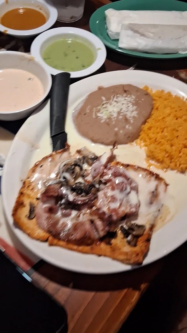 Colorful plates of Mexican dishes on a restaurant table.